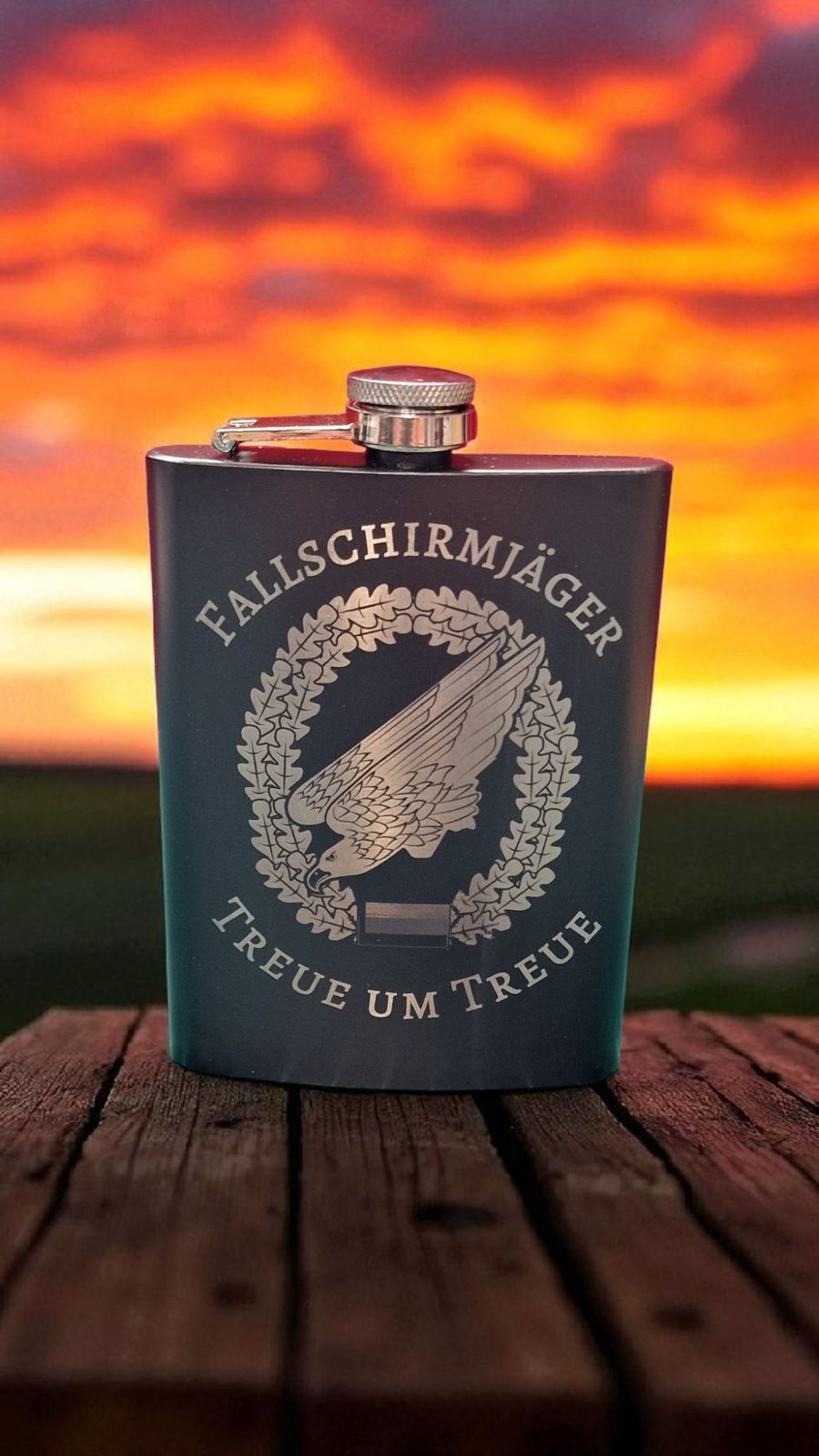 Gravierter Flachmann mit Fallschirmjäger-Emblem vor dramatischem Sonnenuntergang